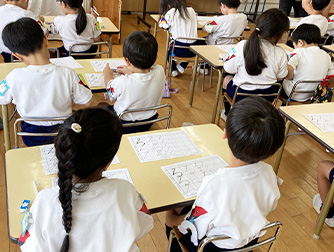 硬筆教室でひらがなを練習する園児